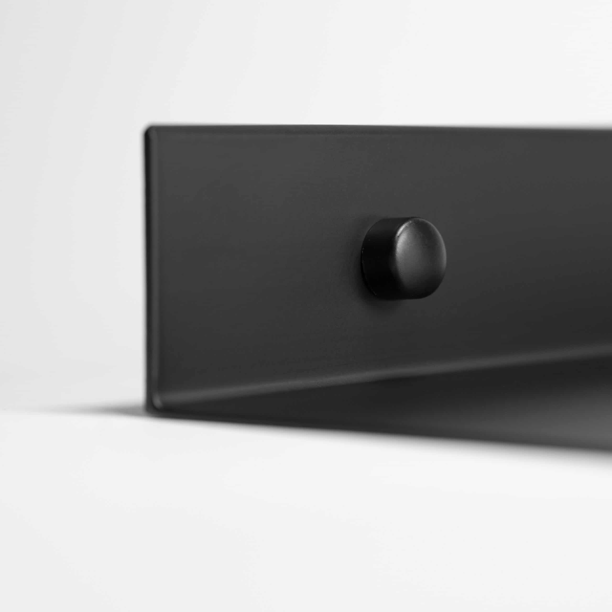 Monteren van een zwart metalen plank aan de muur